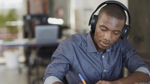 A student wearing headphones and doing work.
